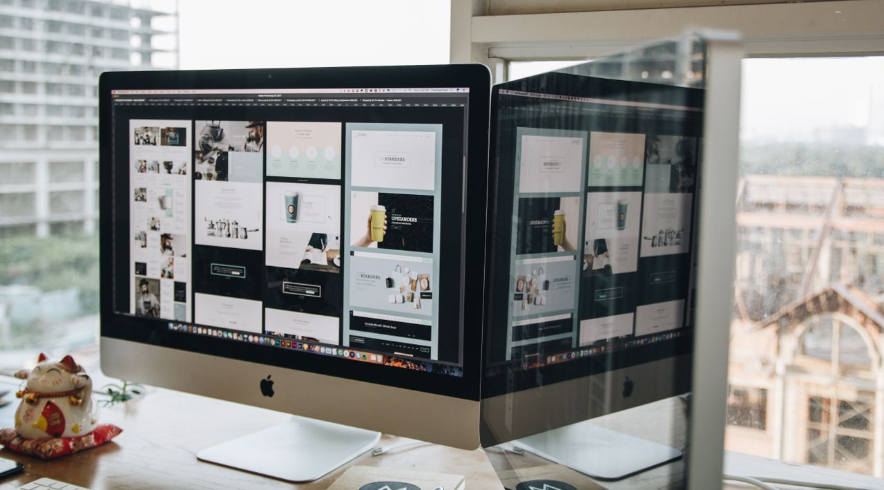 our-story Deux écrans posés sur un bureau, illustrant la conception web dans un environnement de bureau moderne.